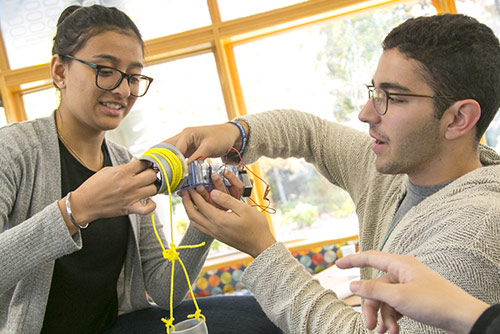 Two engineering students assembling a technical project